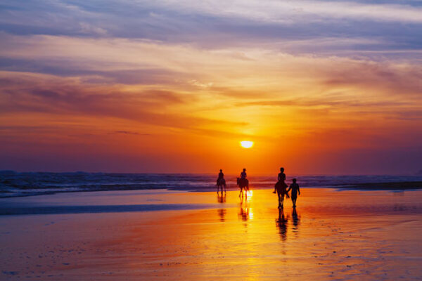 Reiten am Strand im Sonnenuntergang